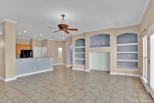 unfurnished living room featuring built in shelves, ceiling fan, crown molding, and light tile patterned flooring