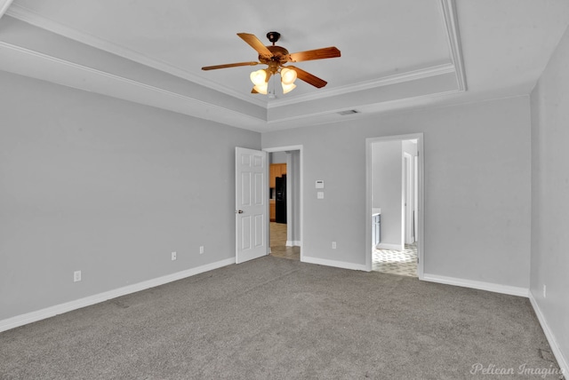 spare room featuring ornamental molding, a raised ceiling, ceiling fan, and carpet flooring