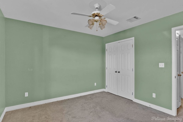 unfurnished bedroom with ceiling fan, light colored carpet, and a closet