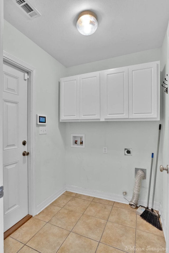 clothes washing area featuring gas dryer hookup, cabinets, washer hookup, light tile patterned flooring, and hookup for an electric dryer