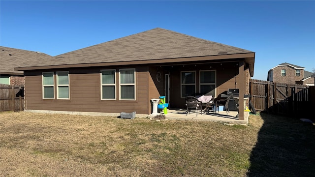 back of property with a yard and a patio