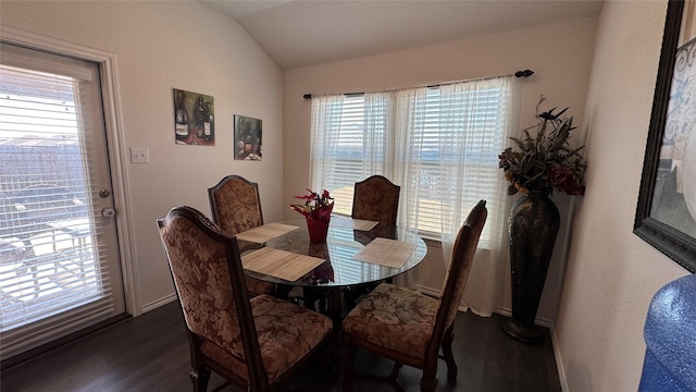 dining area featuring dark hardwood / wood-style floors and vaulted ceiling