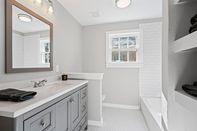 full bathroom with tile patterned floors, vanity, tiled shower / bath combo, and toilet