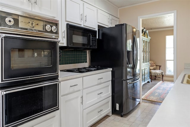 kitchen featuring black appliances, decorative backsplash, ornamental molding, a textured ceiling, and white cabinetry