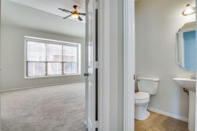 bathroom featuring tile patterned flooring, ceiling fan, toilet, and sink