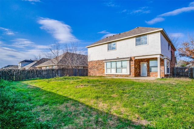 back of house with a lawn and a patio area