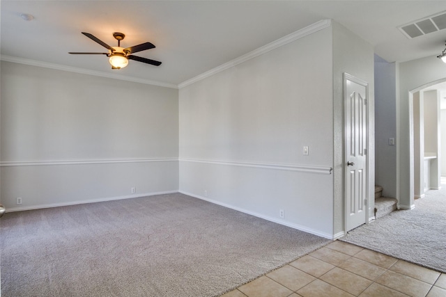 carpeted spare room with ceiling fan and crown molding