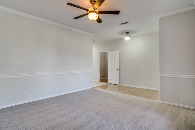 empty room featuring light carpet, crown molding, and ceiling fan