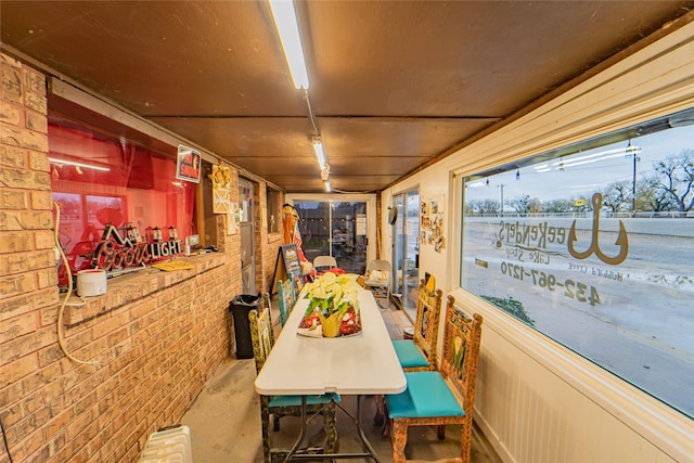 dining space featuring brick wall