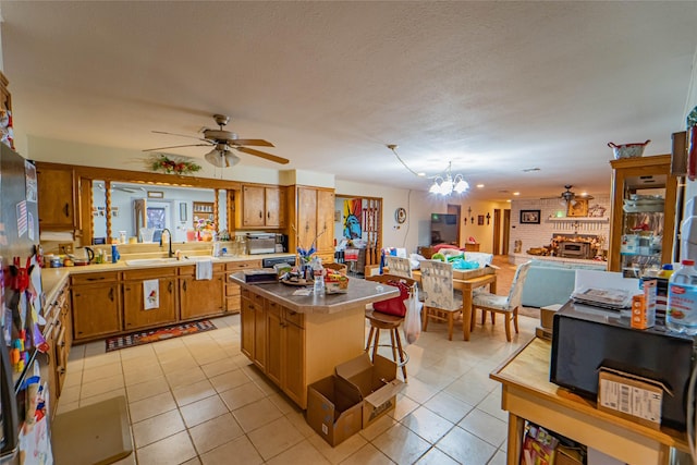 kitchen with a kitchen island, sink, a breakfast bar area, and light tile patterned floors