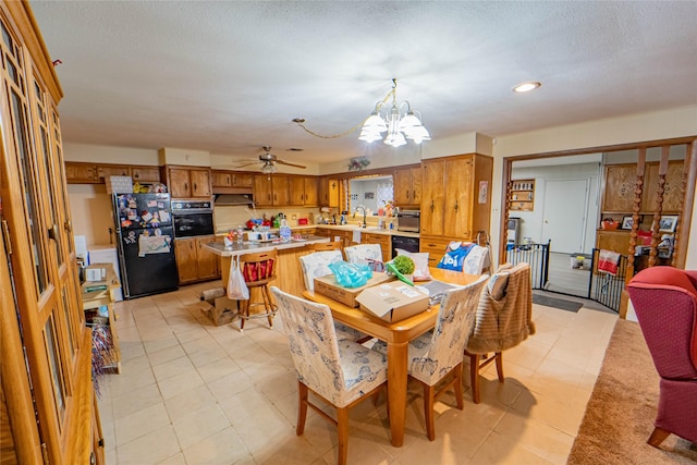 dining room featuring sink, ceiling fan with notable chandelier, and a textured ceiling