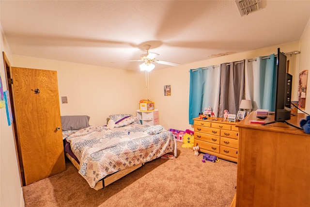 bedroom with carpet, a textured ceiling, and ceiling fan