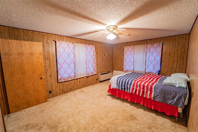 bedroom with carpet flooring, a textured ceiling, and wooden walls