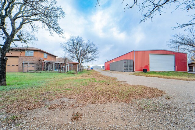 view of yard featuring a garage and an outdoor structure