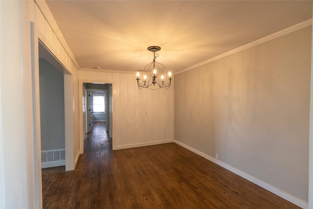 empty room featuring a notable chandelier, ornamental molding, and dark hardwood / wood-style floors