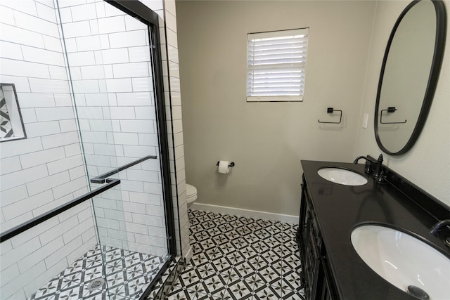 bathroom featuring toilet, tile patterned flooring, a shower with door, and vanity