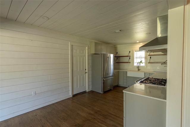 kitchen with wood ceiling, stainless steel appliances, dark hardwood / wood-style flooring, wooden walls, and wall chimney exhaust hood