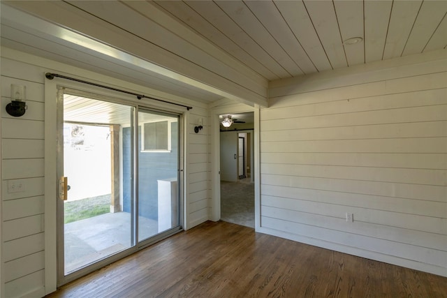 interior space featuring wood walls, a wealth of natural light, and hardwood / wood-style floors