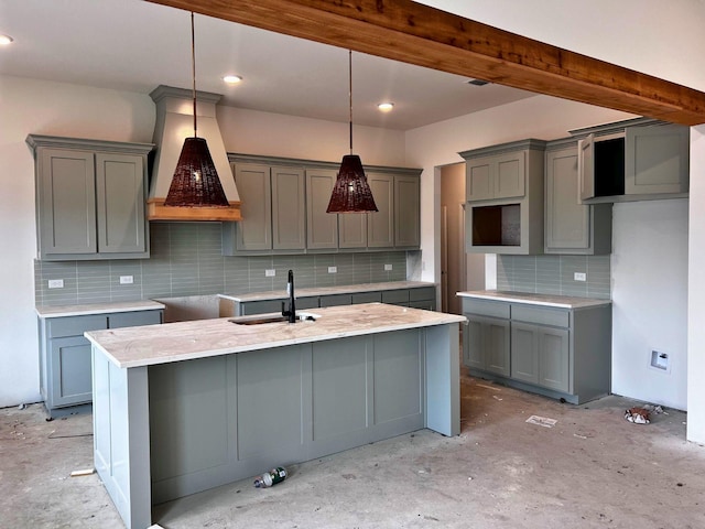 kitchen with premium range hood, sink, gray cabinetry, and decorative light fixtures