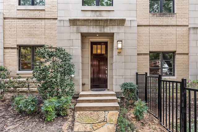 doorway to property featuring fence