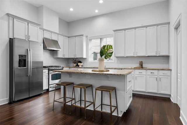 kitchen with a center island, light stone countertops, tasteful backsplash, stainless steel fridge with ice dispenser, and gas stove