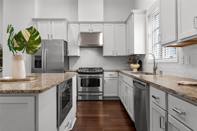 kitchen featuring white cabinets, range hood, appliances with stainless steel finishes, and sink