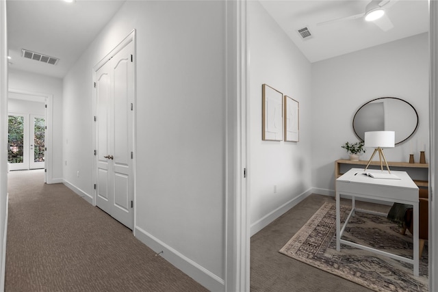 hallway with dark carpet and french doors