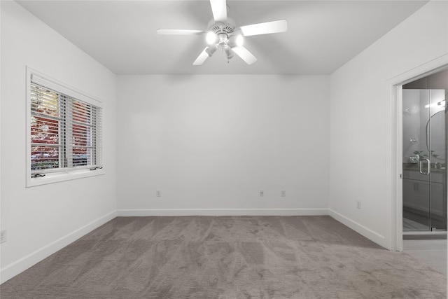 carpeted spare room featuring ceiling fan