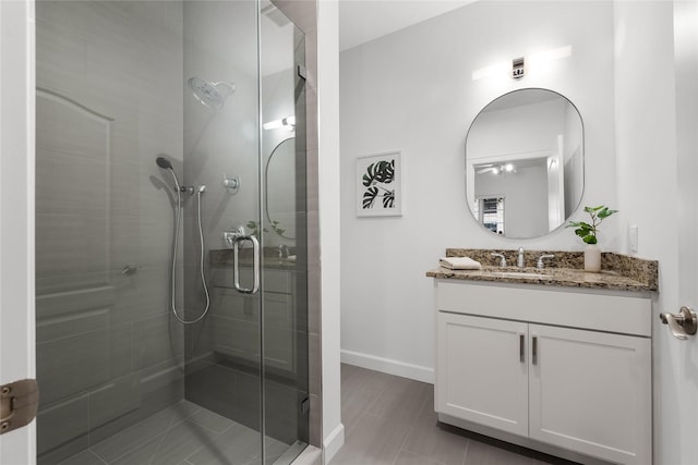 bathroom with a shower with shower door and vanity