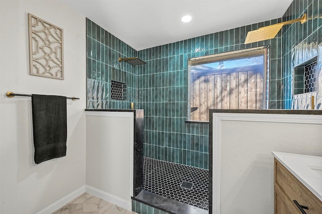 bathroom featuring tiled shower and vanity