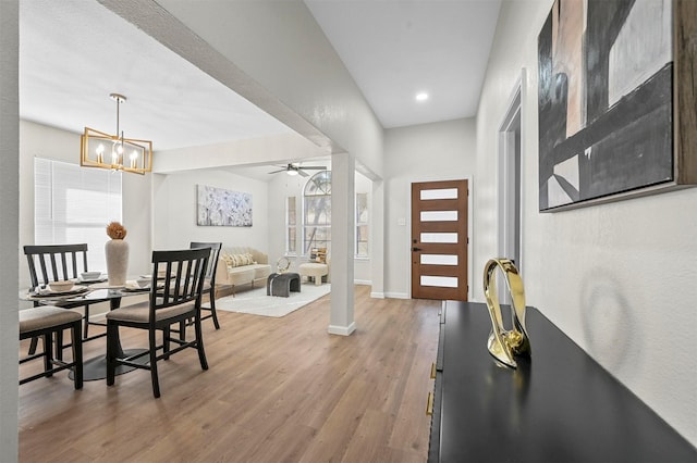 foyer entrance featuring hardwood / wood-style floors, a healthy amount of sunlight, and ceiling fan with notable chandelier