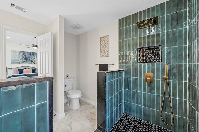 bathroom with ceiling fan, toilet, and tiled shower