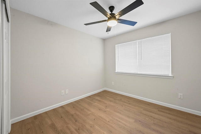 empty room with ceiling fan and light hardwood / wood-style flooring