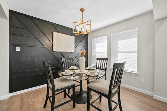 dining room featuring a healthy amount of sunlight, light wood-type flooring, and a chandelier