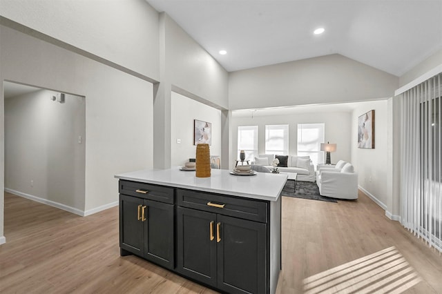 kitchen featuring a center island, high vaulted ceiling, and light hardwood / wood-style flooring