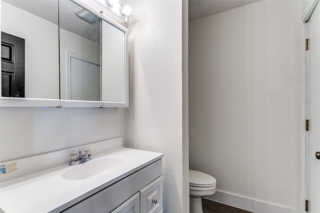 bathroom featuring vanity, toilet, and a textured ceiling