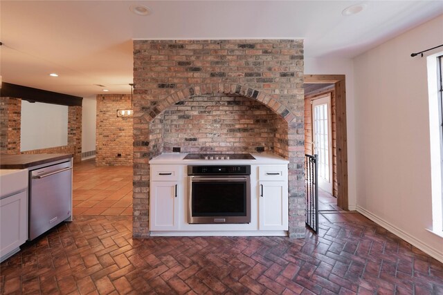 kitchen with white cabinets, appliances with stainless steel finishes, and pendant lighting