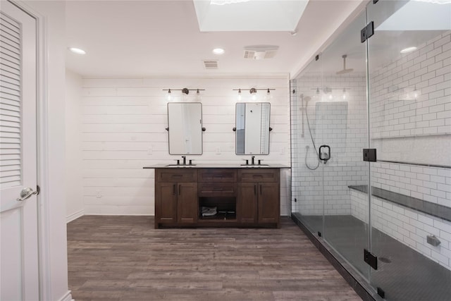 bathroom with vanity, a shower with shower door, and wood-type flooring