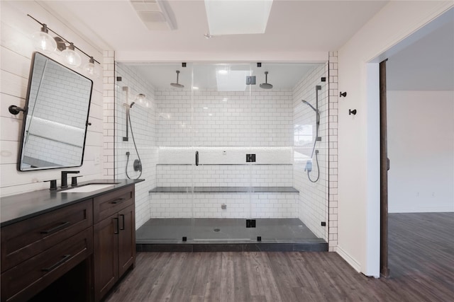 bathroom with hardwood / wood-style floors, vanity, and a shower with shower door