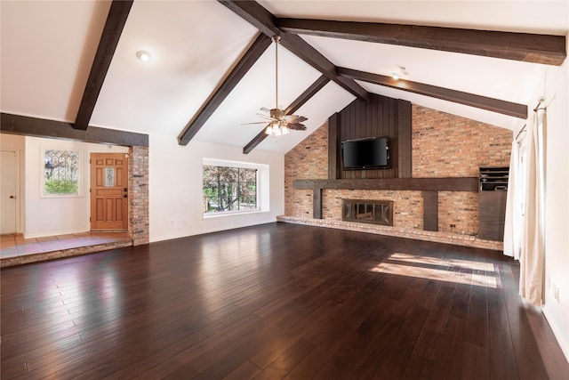 unfurnished living room featuring vaulted ceiling with beams, ceiling fan, dark hardwood / wood-style floors, and a brick fireplace