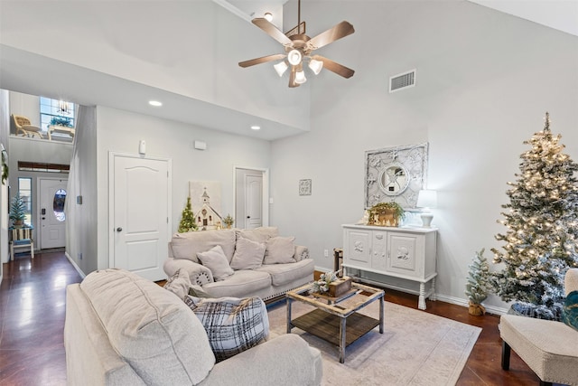 living room with ceiling fan, dark hardwood / wood-style floors, and a high ceiling