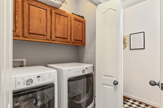 washroom with washing machine and clothes dryer and cabinets