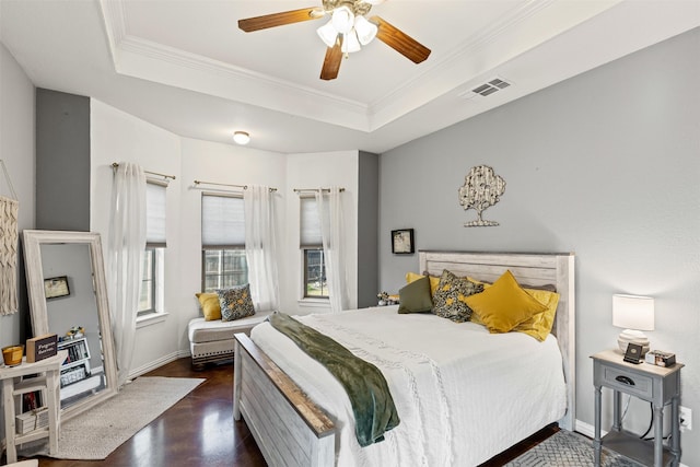 bedroom with a tray ceiling, ceiling fan, dark hardwood / wood-style flooring, and ornamental molding