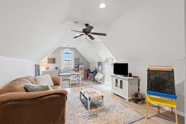 living room with ceiling fan, hardwood / wood-style floors, and vaulted ceiling