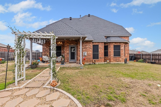 rear view of house featuring a pergola, a patio area, and a lawn