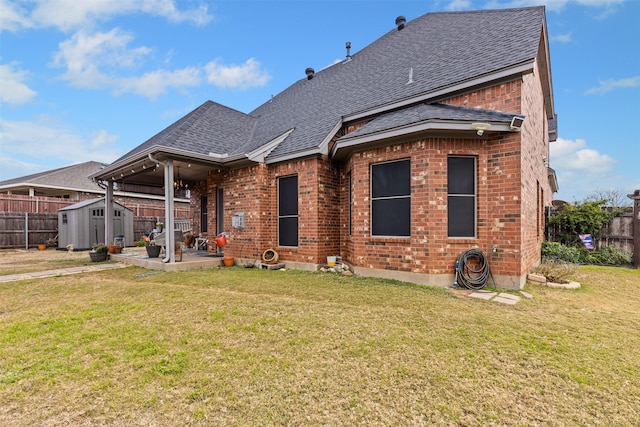 rear view of house with a lawn, a patio, and a storage unit