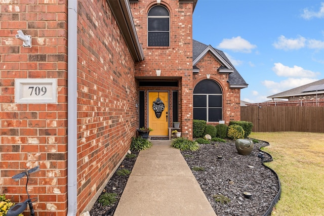 entrance to property featuring a lawn