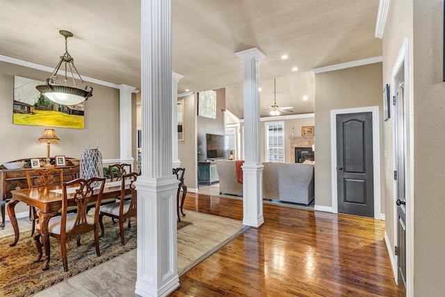 dining space with hardwood / wood-style floors, ornate columns, ceiling fan, and ornamental molding