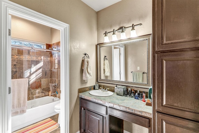 full bathroom with toilet, vanity, and tiled shower / bath