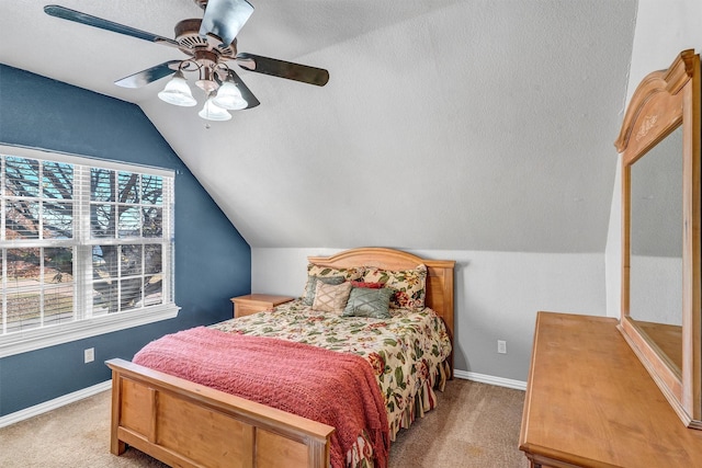 carpeted bedroom featuring ceiling fan, lofted ceiling, and a textured ceiling